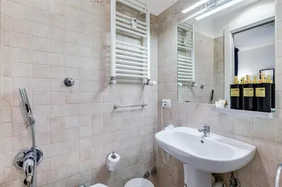 a bathroom with a sink and a mirror at VIVILO COLLECTION - Marche 54 Apart 4bdr - Close to Via Veneto in Rome