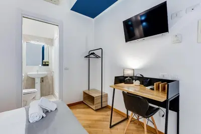 a bedroom with a desk and a bed and a bathroom at VIVILO COLLECTION - Marche 54 Apart 4bdr - Close to Via Veneto in Rome