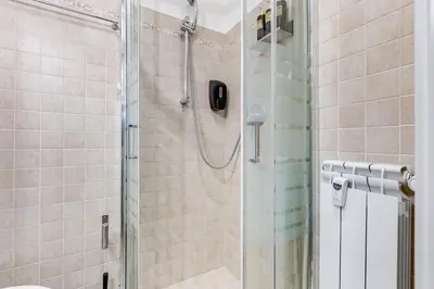a shower with a glass door in a bathroom at VIVILO COLLECTION - Marche 54 Apart 4bdr - Close to Via Veneto in Rome