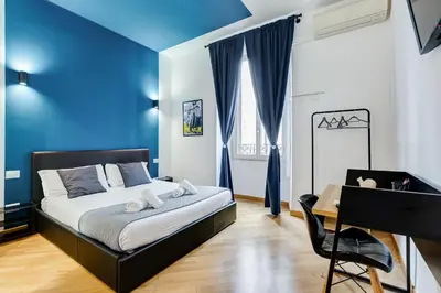 a bedroom with blue walls and a bed with a desk at VIVILO COLLECTION - Marche 54 Apart 4bdr - Close to Via Veneto in Rome
