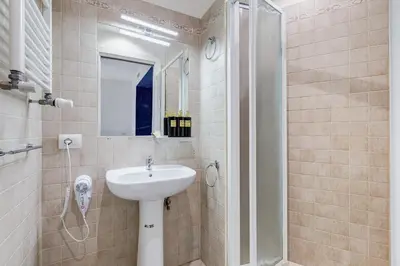 a bathroom with a sink and a shower at VIVILO COLLECTION - Marche 54 Apart 4bdr - Close to Via Veneto in Rome