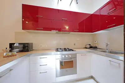 a kitchen with red cabinets and a sink at Cinque in Rome