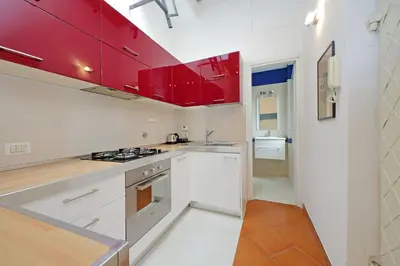 a kitchen with red cabinets and a stove top oven at Cinque in Rome