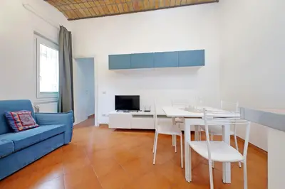 a living room with a table and a blue couch at Cinque in Rome