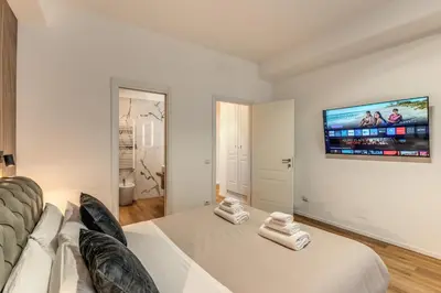 a bedroom with a large bed and a tv on the wall at Vatican Private Apartment in Rome