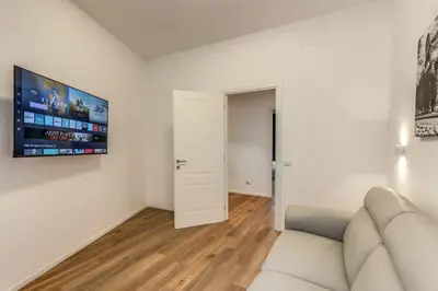 a living room with a couch and a tv on the wall at Vatican Private Apartment in Rome