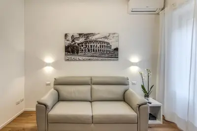 a couch in a living room with a painting on the wall at Vatican Private Apartment in Rome