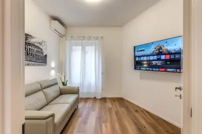 a living room with a couch and a tv on a wall at Vatican Private Apartment in Rome