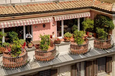 a building with a bunch of potted plants on it at The Inn at the Spanish Steps Exclusive Collection - The Nest Penthouse in Rome