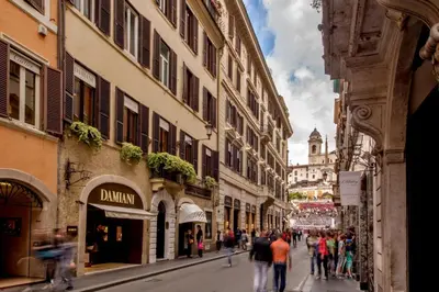 a group of people walking down a street with buildings at The Inn at the Spanish Steps Exclusive Collection - The Nest Penthouse in Rome