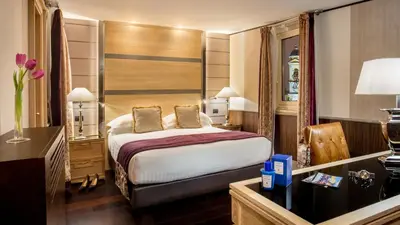 a hotel room with a bed and a dresser at The Inn at the Spanish Steps Exclusive Collection - The Nest Penthouse in Rome