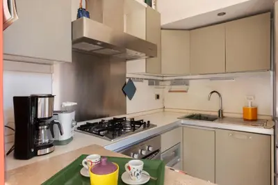 a kitchen with white cabinets and a stove top oven at Casa Emma - Charme Holidays in Rome