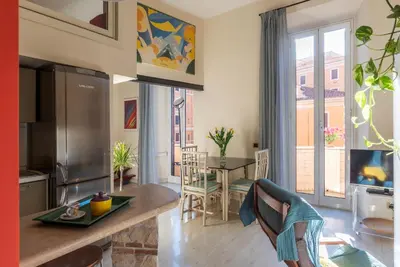 a kitchen and living room with a table and a window at Casa Emma - Charme Holidays in Rome