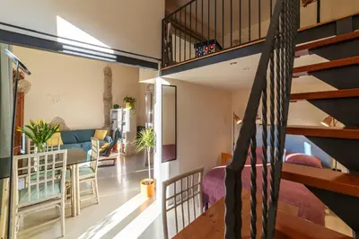 an open living room and dining room with a spiral staircase at Casa Emma - Charme Holidays in Rome
