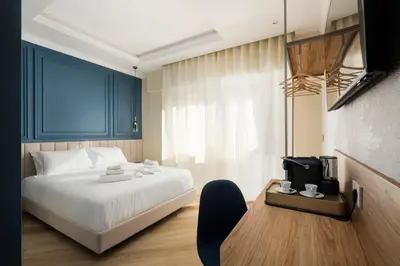 a bedroom with a bed and a tv and a chair at Eudora Guesthouse Roma in Rome