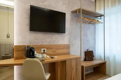 a room with a desk with a television on a wall at Eudora Guesthouse Roma in Rome