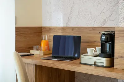 a laptop computer sitting on a counter with a coffee maker at Eudora Guesthouse Roma in Rome