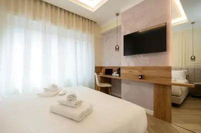 a hotel room with a bed and a flat screen tv at Eudora Guesthouse Roma in Rome