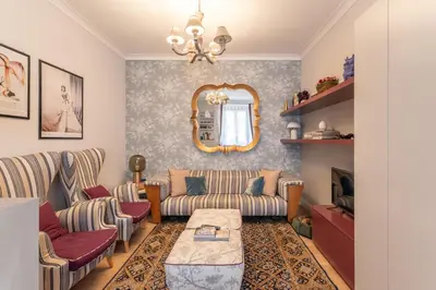 a living room with two couches and a mirror at La casa di Nina in Via Veneto in Rome