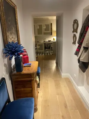 a living room with a blue chair and a kitchen at La casa di Nina in Via Veneto in Rome