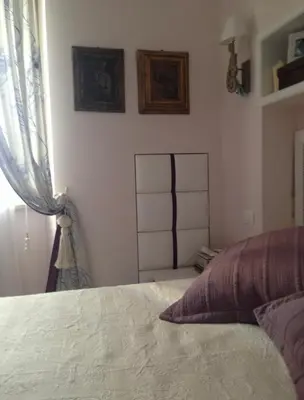 a bedroom with a white bed and a window at La casa di Nina in Via Veneto in Rome