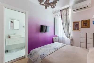 a bedroom with purple walls and a bed and a sink at La casa di Nina in Via Veneto in Rome