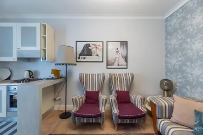 a living room with two chairs and a kitchen at La casa di Nina in Via Veneto in Rome