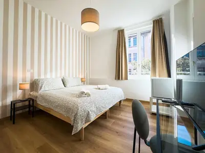 a bedroom with a bed and a desk and a television at Laura's Rooms in Rome