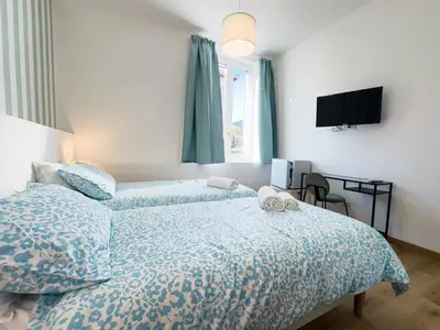 a bedroom with a bed with a blue comforter and a window at Laura's Rooms in Rome
