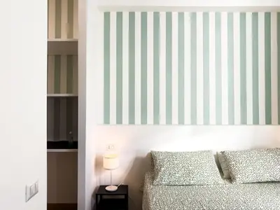 a bedroom with a bed and a striped wall at Laura's Rooms in Rome