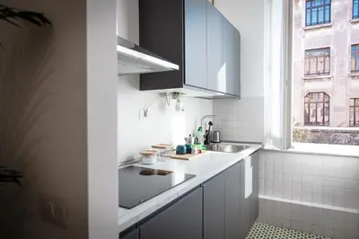 a white kitchen with a sink and a window at Laura's Rooms in Rome