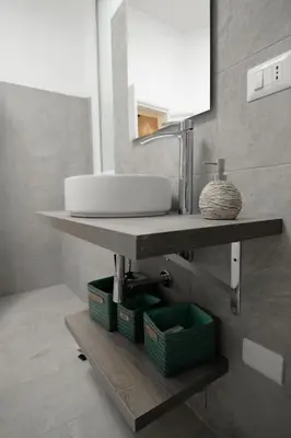 a bathroom with a sink and two baskets on a shelf at Crezy House Trilussa in Rome