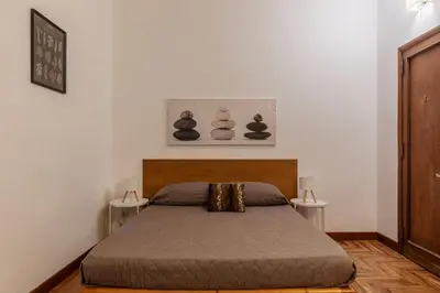 a bedroom with a bed with two tables at GuestHost - Charming Apartment near Piazza di Spagna in Rome