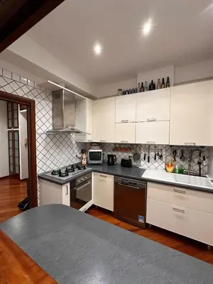 a kitchen with white cabinets and black counter tops at Casa Turchina in Rome