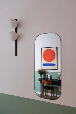 a mirror on a wall with a table and a chair at Interno 12 in Rome