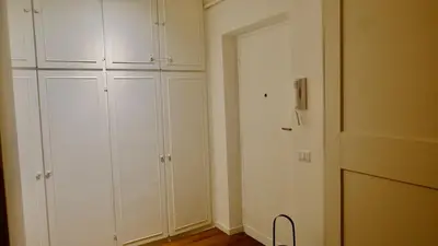 a white room with white cabinets and a door at La Nuova Casa Di Zia - near metro A Ponte Lungo in Rome