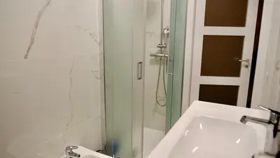 a bathroom with a sink and a glass shower at La Nuova Casa Di Zia - near metro A Ponte Lungo in Rome