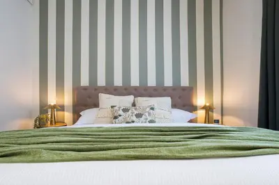 a bedroom with a bed with green and white stripes at Morgana - Charming Apartment Close to Vatican in Rome
