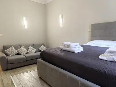 a bedroom with a bed and a couch at Trastevere Bertani MiniApartment in Rome