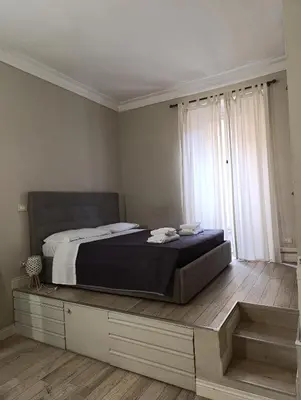 a bedroom with a bed and a large window at Trastevere Bertani MiniApartment in Rome