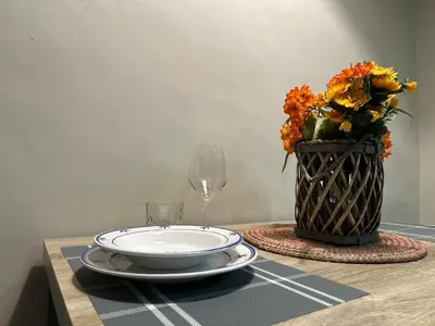 a table with a plate and a vase with flowers at Trastevere Bertani MiniApartment in Rome