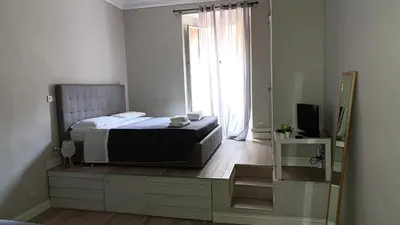 a bedroom with a bed and a large window at Trastevere Bertani MiniApartment in Rome