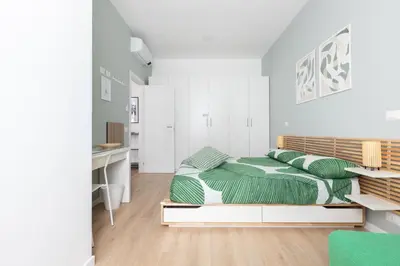 a white bedroom with a bed and a desk at Kimera42 Casa Vacanze in Rome