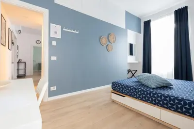 a bedroom with a bed and a blue wall at Kimera42 Casa Vacanze in Rome