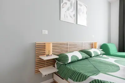 a bedroom with a bed with green and white sheets at Kimera42 Casa Vacanze in Rome