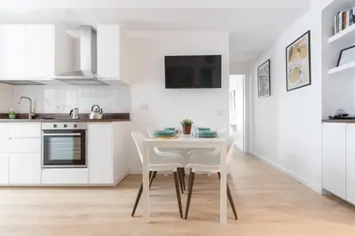 a white kitchen with a white table and chairs at Kimera42 Casa Vacanze in Rome
