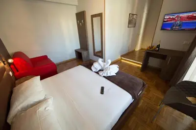 a bedroom with a white bed and a red couch at Love of Rome in Rome
