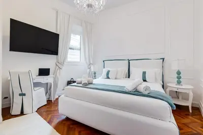 a white bedroom with a bed and a tv at New opening Spagna Suite in Rome