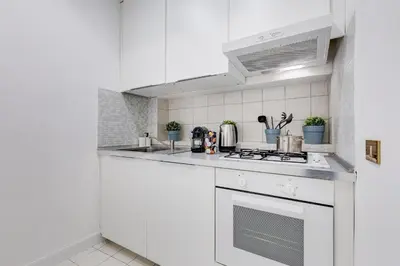 a white kitchen with a stove top oven at New opening Spagna Suite in Rome
