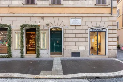 a building with a green door on a street at New opening Spagna Suite in Rome